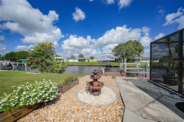 view of yard featuring glass enclosure, a water view, and a dock