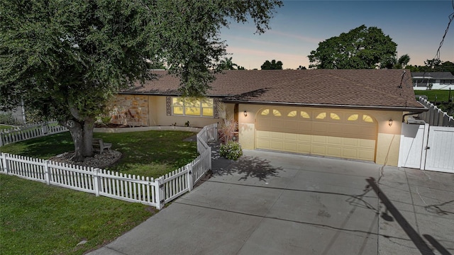 ranch-style house featuring a lawn and a garage