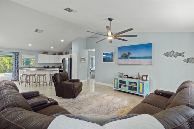 living room with ceiling fan, lofted ceiling, sink, and light tile patterned floors