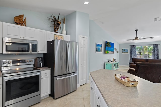 kitchen featuring appliances with stainless steel finishes, ceiling fan, white cabinets, lofted ceiling, and light tile patterned flooring