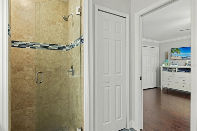 bathroom featuring crown molding, hardwood / wood-style floors, and walk in shower