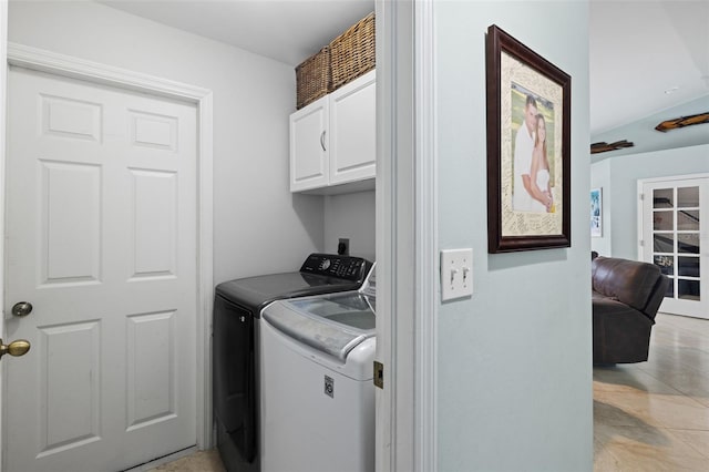 clothes washing area featuring cabinets and washing machine and clothes dryer