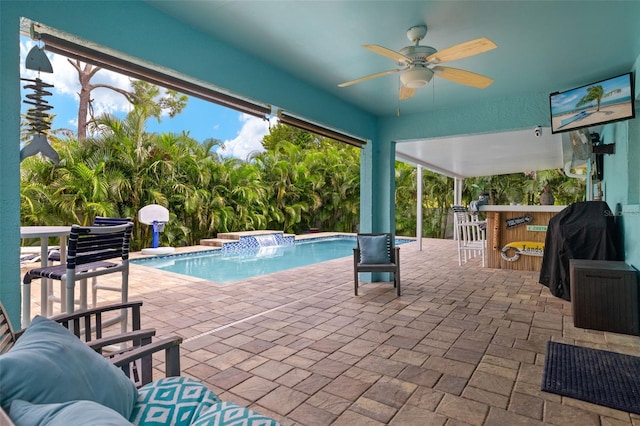 view of swimming pool with an outdoor bar, a jacuzzi, pool water feature, ceiling fan, and a patio area