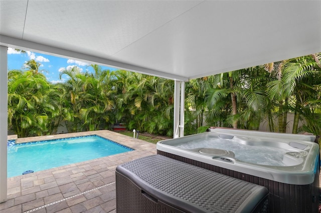 view of pool with a patio and a hot tub