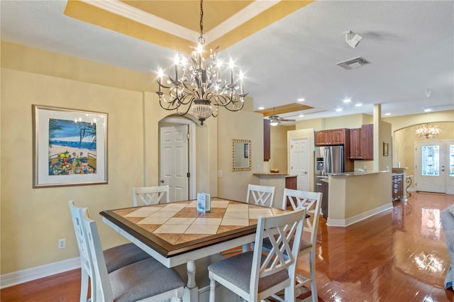 dining area with ceiling fan with notable chandelier and hardwood / wood-style floors