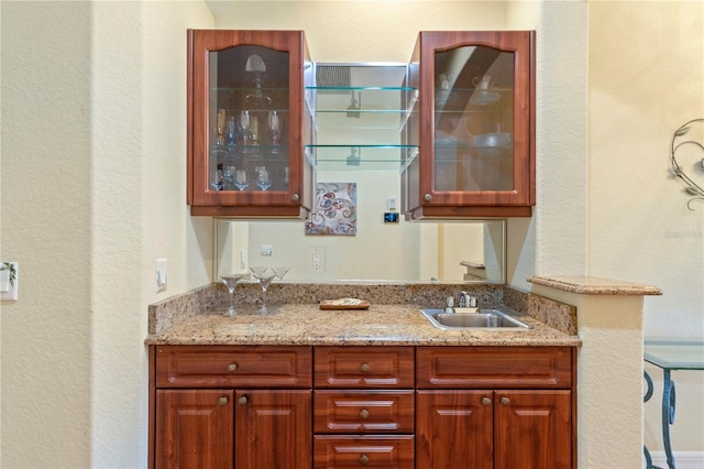 interior space with light stone countertops and sink