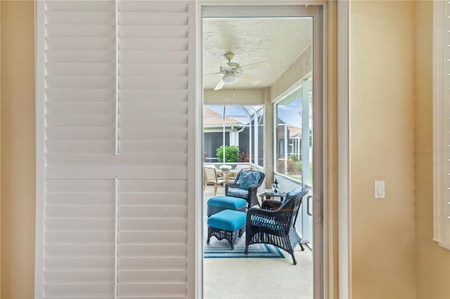 entryway with ceiling fan and carpet floors