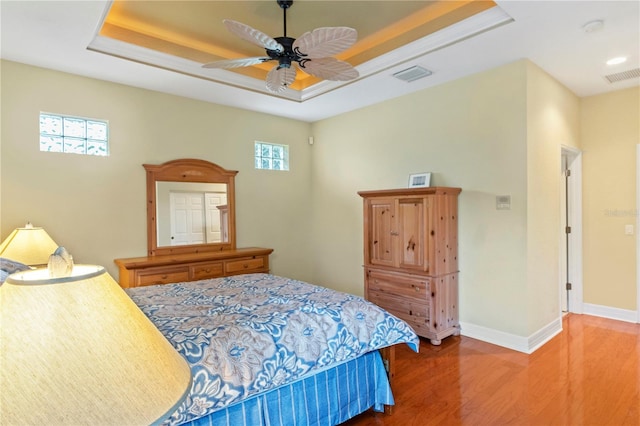 bedroom featuring ceiling fan, a raised ceiling, and hardwood / wood-style flooring