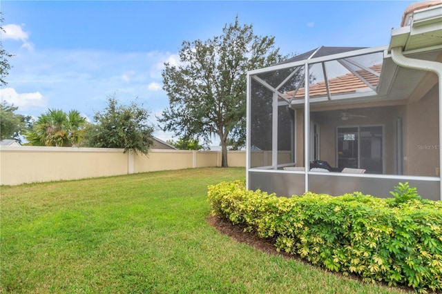 view of yard featuring ceiling fan and a lanai