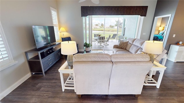 living room with a healthy amount of sunlight, dark hardwood / wood-style flooring, and ceiling fan