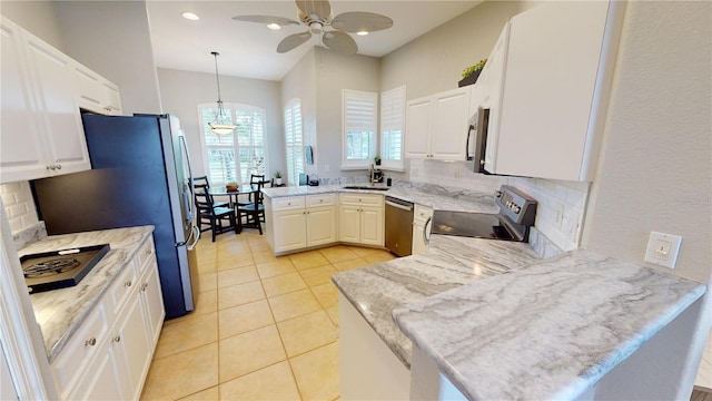 kitchen with pendant lighting, ceiling fan with notable chandelier, white cabinetry, kitchen peninsula, and stainless steel appliances