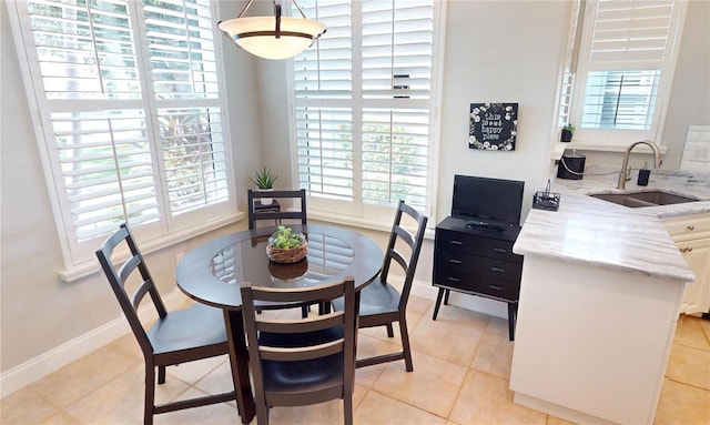 tiled dining space featuring plenty of natural light and sink