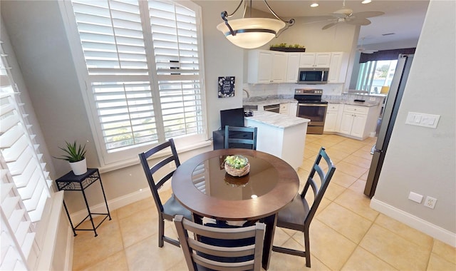 dining room featuring light tile patterned flooring, sink, and ceiling fan