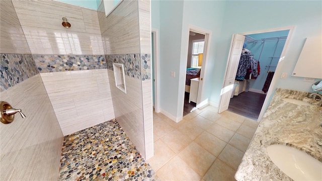 bathroom featuring vanity, a tile shower, and tile patterned floors