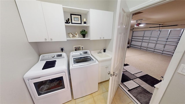 laundry area with sink, washer and dryer, and cabinets