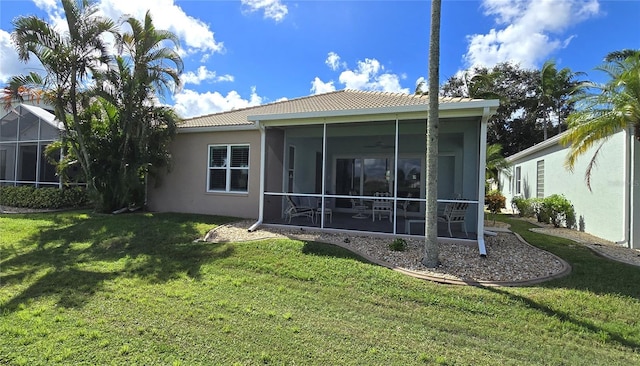 rear view of house with a sunroom and a lawn