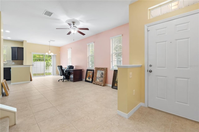 foyer entrance featuring ceiling fan with notable chandelier and light tile patterned floors