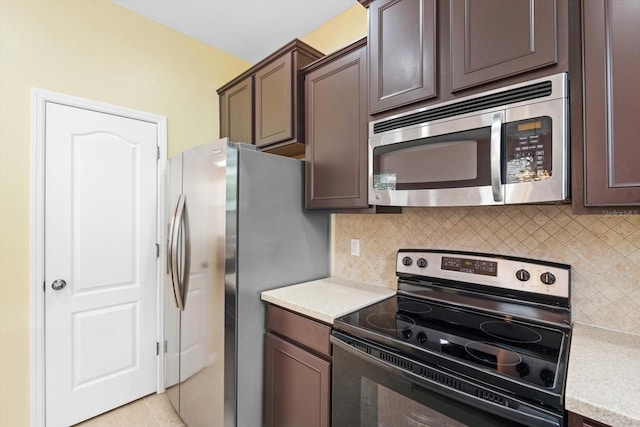 kitchen with appliances with stainless steel finishes, decorative backsplash, dark brown cabinets, and light tile patterned floors