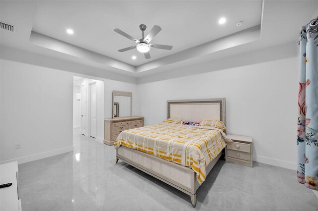 bedroom with ceiling fan and a raised ceiling