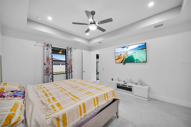 bedroom with ceiling fan and a raised ceiling