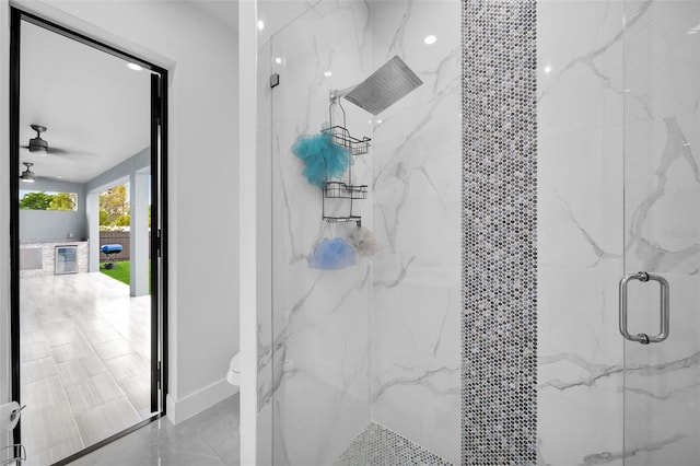 bathroom featuring ceiling fan, an enclosed shower, and toilet