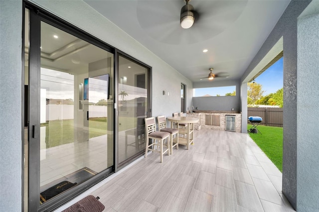 view of patio / terrace with ceiling fan, wine cooler, and an outdoor kitchen