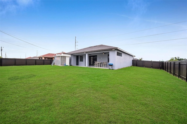 back of property featuring a lawn, ceiling fan, and a patio