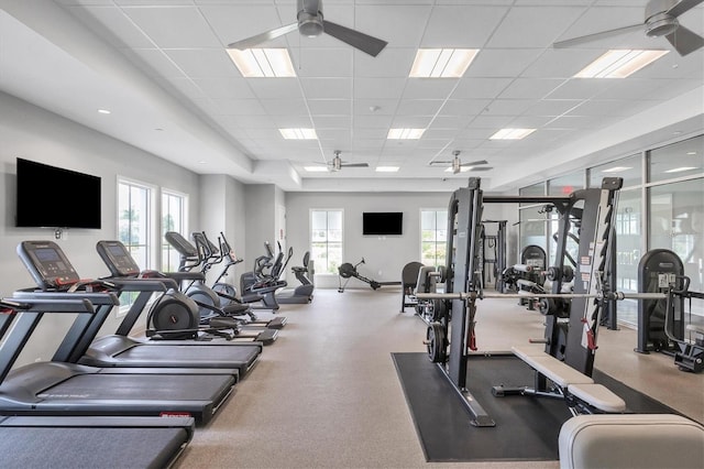 workout area with ceiling fan, a drop ceiling, and plenty of natural light