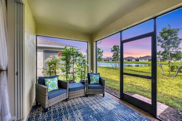 unfurnished sunroom featuring a water view