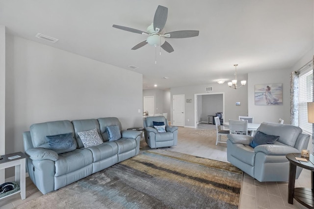 living room with ceiling fan with notable chandelier, light wood-type flooring, and visible vents