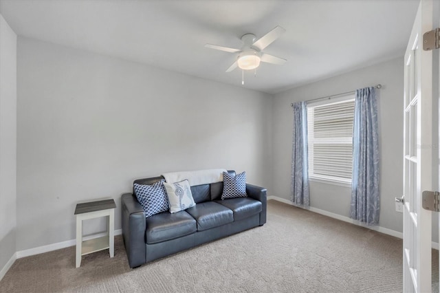 carpeted living room featuring a ceiling fan and baseboards