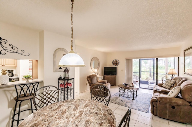 tiled living room featuring a textured ceiling