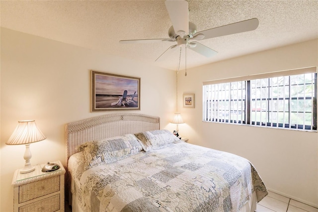 tiled bedroom with ceiling fan and a textured ceiling