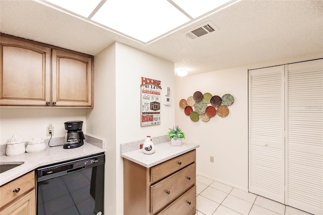 kitchen featuring a textured ceiling, light brown cabinetry, dishwasher, and light tile patterned floors