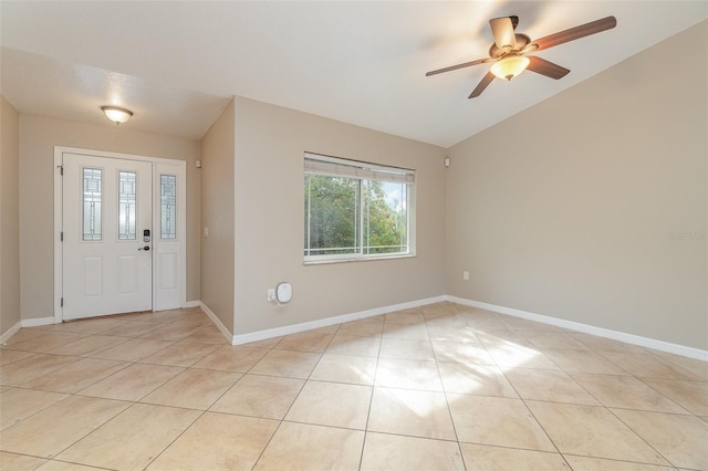 entryway featuring ceiling fan, light tile patterned floors, and vaulted ceiling