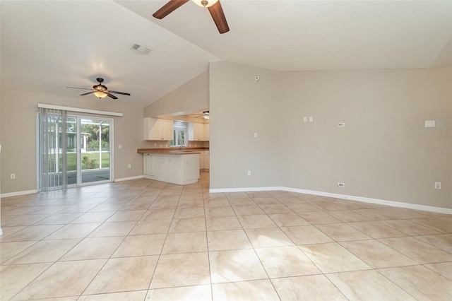 unfurnished living room with light tile patterned floors, lofted ceiling, and sink