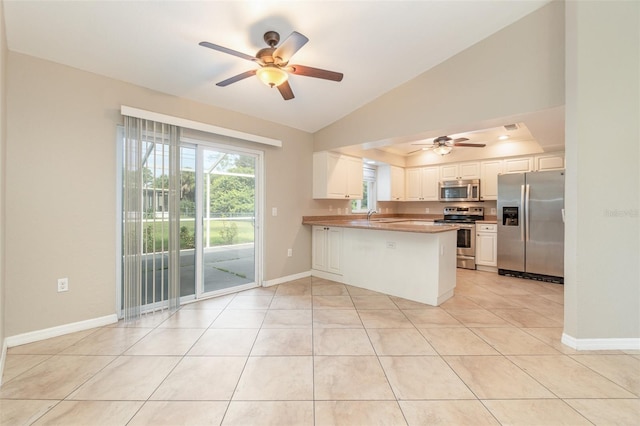 kitchen featuring lofted ceiling, white cabinets, ceiling fan, appliances with stainless steel finishes, and kitchen peninsula