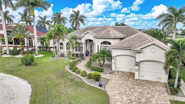 mediterranean / spanish-style house featuring a front yard and a garage