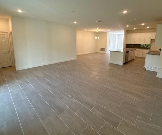 unfurnished living room with light hardwood / wood-style flooring and a notable chandelier