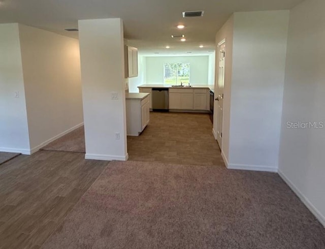 kitchen featuring dishwasher, white cabinetry, hardwood / wood-style floors, and sink