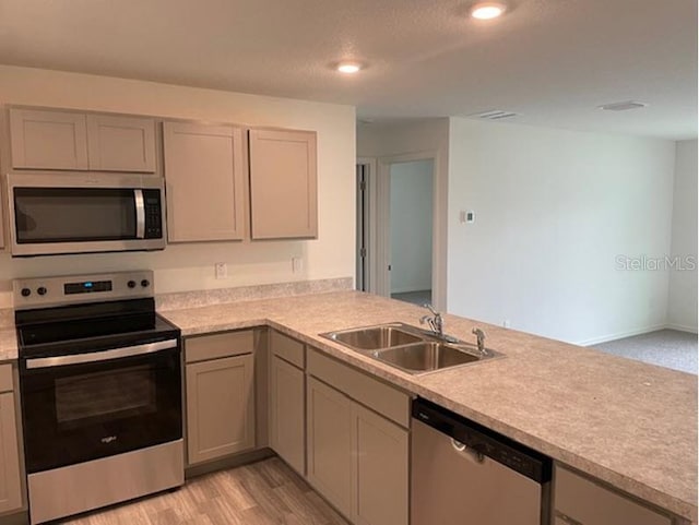 kitchen featuring gray cabinetry, appliances with stainless steel finishes, sink, and light hardwood / wood-style flooring