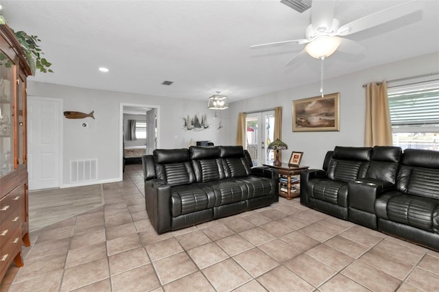 living room with a healthy amount of sunlight, light tile patterned floors, and ceiling fan