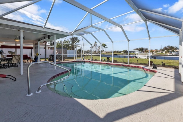 view of swimming pool with ceiling fan, a patio area, and a lanai