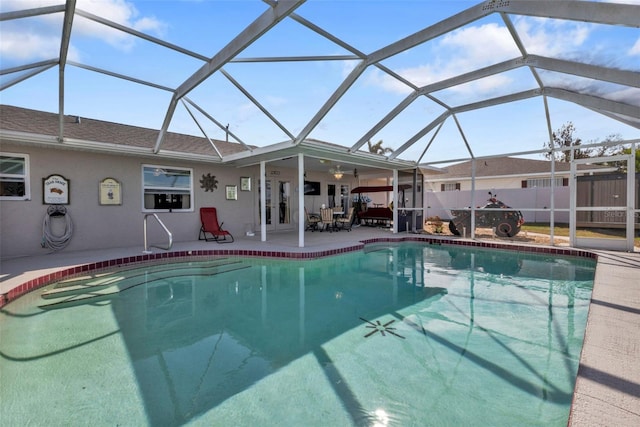 view of swimming pool featuring a patio, ceiling fan, and glass enclosure