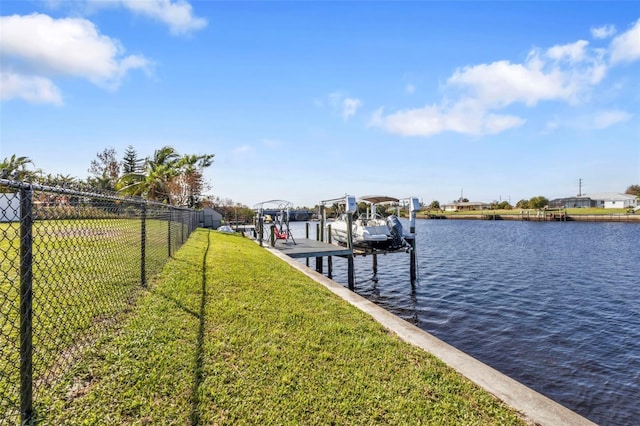 view of dock with a yard and a water view