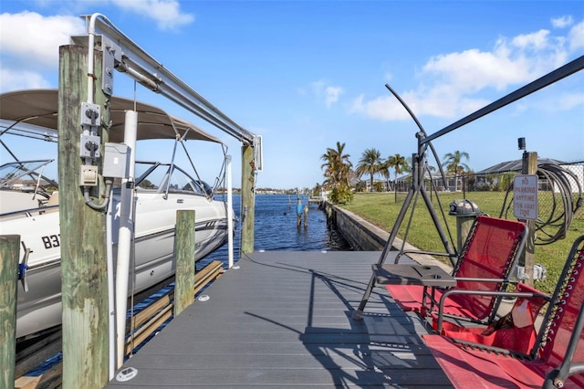 dock area with a water view and a lawn