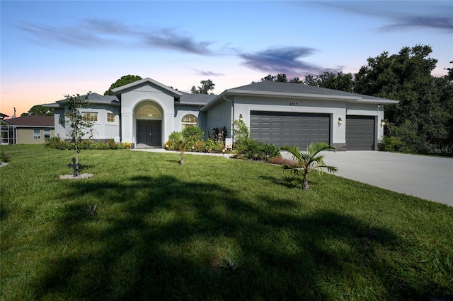 ranch-style home with a garage and a lawn