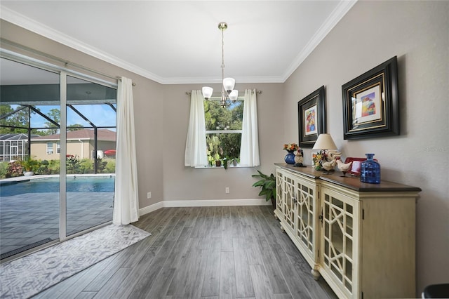 unfurnished dining area with a wealth of natural light, a notable chandelier, dark hardwood / wood-style floors, and ornamental molding