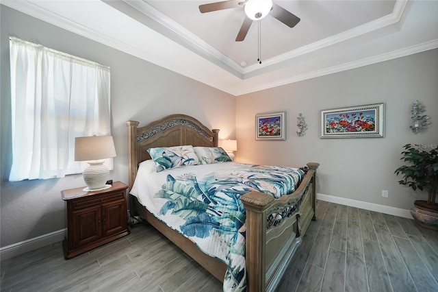 bedroom featuring ceiling fan, light hardwood / wood-style floors, a raised ceiling, and crown molding