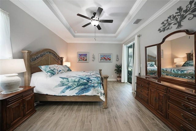 bedroom with a raised ceiling, ceiling fan, crown molding, and light hardwood / wood-style floors